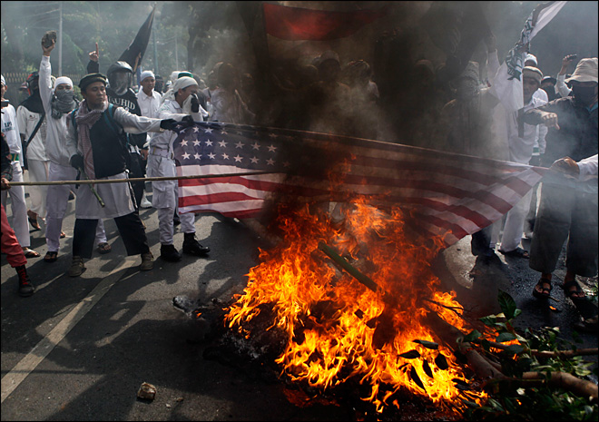  Muslim protesters burn a U.S. flag during a protest against the American-made film "Innocence of Muslims," outside the U.S. Embassy in Jakarta, Indonesia, Monday, Sept. 17, 2012. (AP Photo/Dita Alangkara)